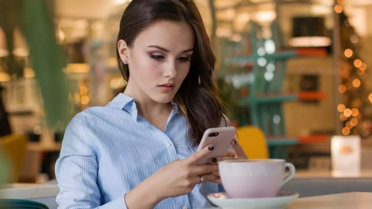 Дівчина в кафе спілкується з чат-ботом ChatGPT